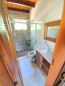 a bathroom with a toilet and a sink and a mirror at ATLANTIC FOREST HOUSE AT FOREST in Angra dos Reis