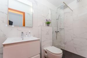 a white bathroom with a toilet and a shower at Villa Bepo in Plano