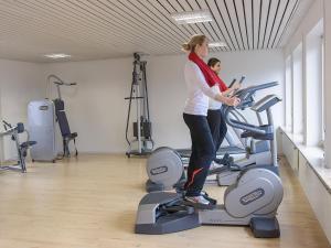 two women standing on a treadmill in a gym at Biohotel Mohren in Deggenhausertal