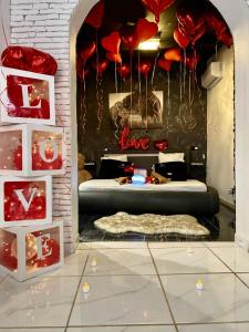 Habitación con cama con corazones rojos y globos en #BBSH, en Goussainville