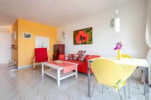 a living room with a red couch and a table at Captivating 1-Bed House in Arona in Arona