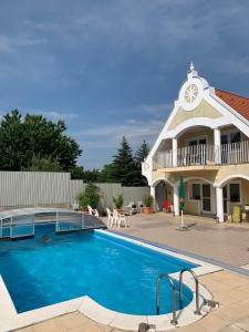 a swimming pool in front of a house at Lilium Villa Hévíz in Hévíz