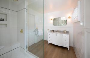 a white bathroom with a shower and a sink at The Colony Palms Hotel and Bungalows - Adults Only in Palm Springs