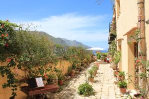 an alley with potted plants on the side of a building at Torre Bennistra in Scopello