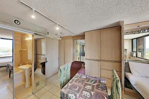 a small bedroom with a bed and a bathroom at Hawaiian Monarch 1607 condo in Honolulu