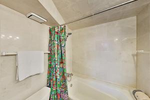 La salle de bains est pourvue de toilettes et d'un rideau de douche. dans l'établissement Hawaiian Monarch 1607 condo, à Honolulu