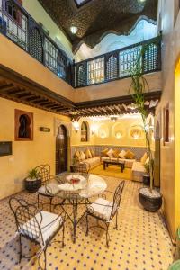a lobby with a table and chairs and a couch at Riad Full Moon in Marrakesh