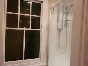 a bathroom with a shower with a window and a shower at Vetrelax Ipswich Woodbridge Apartment in Ipswich