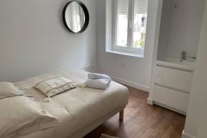 een witte kamer met een bed en een spiegel bij Le Poulorio 5 - Proche Gare By Locly in Lorient