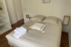 a bed with two pillows on it in a room at Le Poulorio 5 - Proche Gare By Locly in Lorient