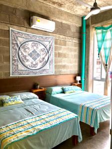 two beds sitting next to each other in a room at Hostal Tortuga in Sayulita