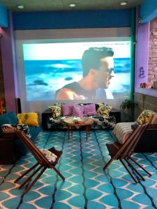 a living room with two chairs and a large screen at Hostal Tortuga in Sayulita