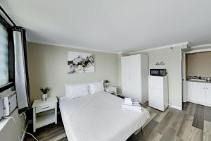 a bedroom with a white bed and a kitchen at Hawaiian Monarch 3707B condo in Honolulu