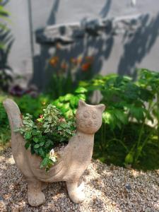 una pequeña estatua de un gato sosteniendo una planta en Hanok Got, en Seúl