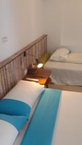 Pokój z 2 łóżkami i stołem z lampką w obiekcie 永勝客棧 w mieście Manzhou