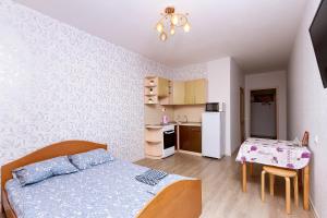 ノヴォシビルスクにあるWelcome Apartment, Уютные Апартаменты, Как дома, Новый дом, Детская площадкаのベッドルーム1室(ベッド1台、テーブル付)、キッチン