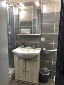 W łazience znajduje się umywalka i lustro. w obiekcie B&B Chez Florence - Chambres d'Hôtes w mieście Montmerle Sur Saône