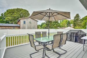 a table and chairs on a deck with an umbrella at Narragansett Escape by Narrow River and Beaches in Narragansett