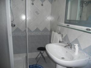 a bathroom with a sink and a glass shower at Le Schiavelle in Surbo