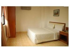 a bedroom with a white bed and a table at TS Hotel - Taman Rinting in Masai