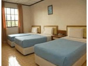TS Hotel - Taman Rinting في ماساي: سريرين في غرفة الفندق بسريرين