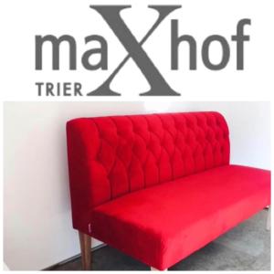 eine rote Couch vor einer Wand in der Unterkunft Maxhof Trier in Trier