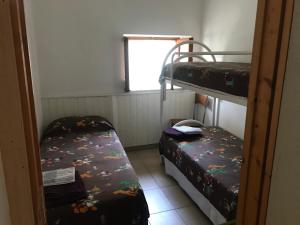 Cette petite chambre comprend 2 lits superposés et une fenêtre. dans l'établissement Apartment Carnevale, à Santa Maria