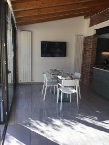 una sala da pranzo con un tavolo e sedie bianche di LUXURY vertical open space a Sangiano