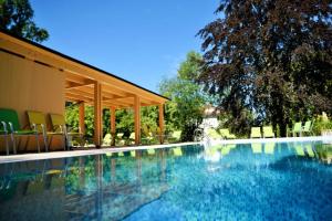 a swimming pool with chairs and a pavilion next to it at Park Hotel & Spa Katharina in Badenweiler