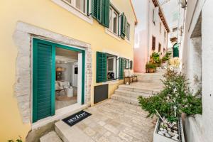 budynek z zielonymi drzwiami i schodami w obiekcie Yellow House Rovinj w Rovinj