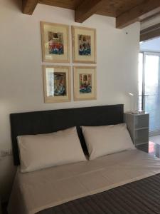 un letto con due cuscini e alcune immagini sul muro di LUXURY vertical open space a Sangiano