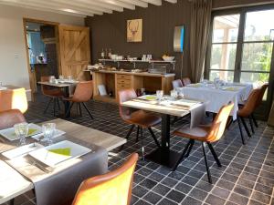 un restaurante con mesas, sillas y una barra en B&B Le Briquemont, en Rochefort