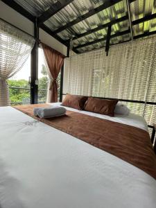 a large bed in a bedroom with a large window at Hotel Pachamama Campestre in Dosquebradas