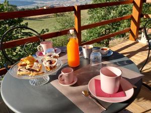 una mesa con un plato de comida y una botella de zumo de naranja en B&B La Casa di Sirio, en Norcia