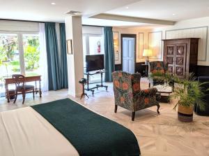a living room with a couch and chairs and a television at Hôtel Le Saint Christophe in La Baule