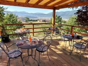 un patio con mesas y sillas en una terraza de madera en B&B La Casa di Sirio, en Norcia