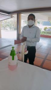 Ein Mann mit einer Gesichtsmaske, der an einem Tresen steht. in der Unterkunft Hotel V.I.P. Regency in Dhanbad