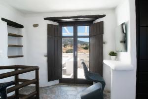 een kamer met een deur met een raam en een stoel bij Aspro Paros Villa in Aspro Chorio Paros