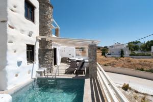 een huis met een zwembad naast een gebouw bij Aspro Paros Villa in Aspro Chorio Paros