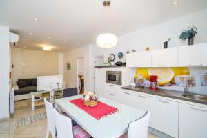 een keuken en een woonkamer met een witte tafel en stoelen bij Apartments Villa Palma in Mlini