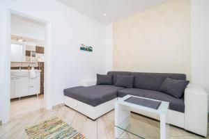 uma sala de estar com um sofá e uma mesa em Apartments Villa Palma em Mlini