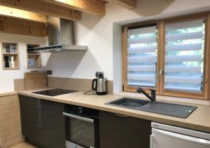 une cuisine avec évier et cuisinière ainsi qu'une fenêtre dans l'établissement Chalet Cristal Trail, à Chamonix-Mont-Blanc