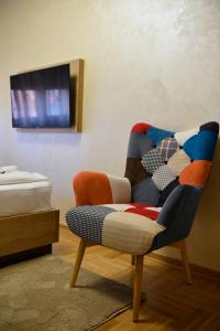 a chair sitting in a room with a tv at Zlatibor apartmani Zlatiborski trenutak in Zlatibor