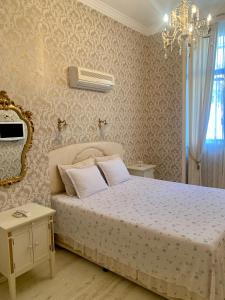 a bedroom with a bed and a chandelier at Tsar Simeon Veliki in Stara Zagora