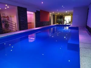 a swimming pool with blue lighting in a house at Az Idill in Cserszegtomaj