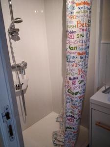 - un rideau de douche avec écriture dans la salle de bains dans l'établissement Marie, à Aytré