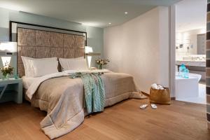 1 dormitorio con 1 cama grande y baño en Hotel Eden Roc - The Leading Hotels of the World en Ascona