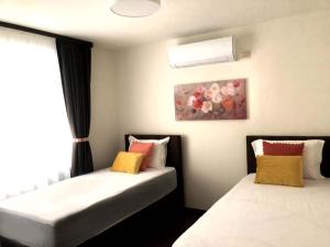 two beds in a room with a window at RELAX Apartments in HASKOVO, Apt1 in Haskovo +12 photos