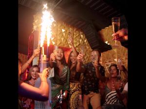 Un groupe de gens levant la main devant une bougie dans l'établissement The Yorkshire Hotel - SHA Certified, à Patong Beach