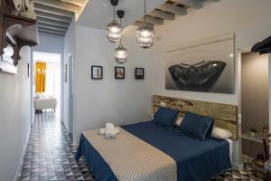 a bedroom with a blue bed with blue pillows at Casa Portus Gaditanus s XVIII Patio Andaluz in El Puerto de Santa María